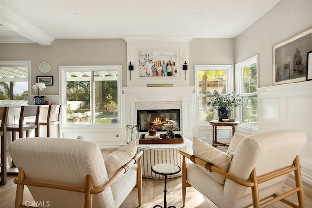 living area featuring beam ceiling and light hardwood / wood-style floors