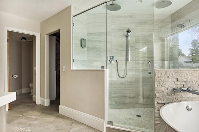 bathroom featuring tile patterned floors, plus walk in shower, and toilet