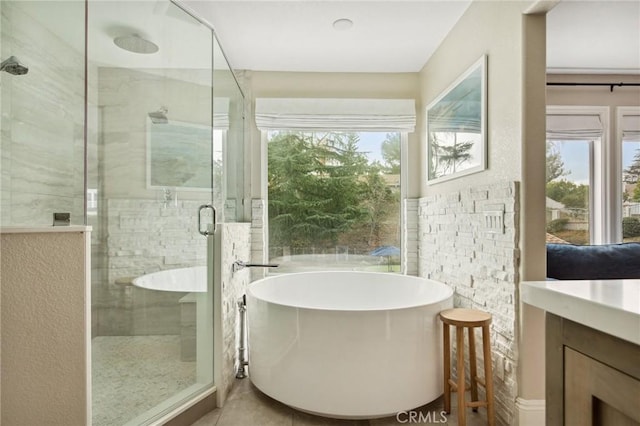 bathroom with tile patterned floors, vanity, independent shower and bath, and tile walls