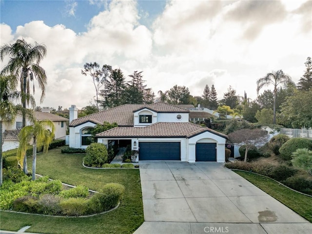 mediterranean / spanish-style home with a garage and a front lawn