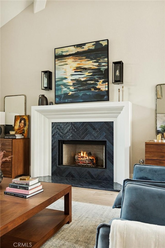 sitting room featuring lofted ceiling, a high end fireplace, and light hardwood / wood-style floors