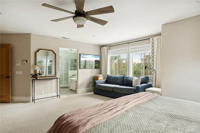 bedroom with ensuite bathroom, light carpet, and ceiling fan