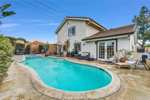 view of swimming pool featuring a patio area and french doors