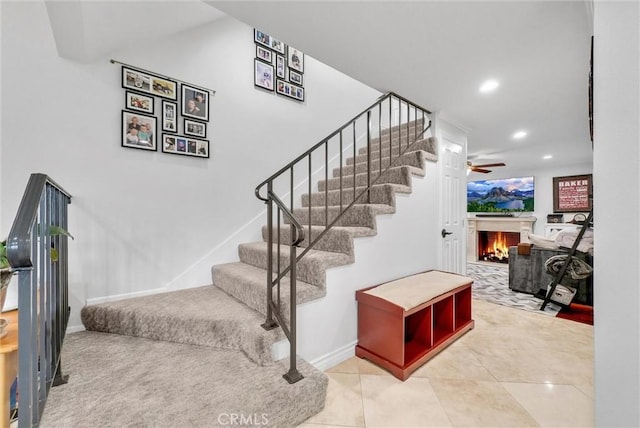 staircase featuring tile patterned floors and ceiling fan