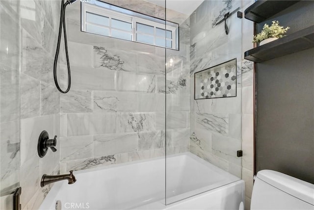 bathroom featuring tiled shower / bath combo and toilet