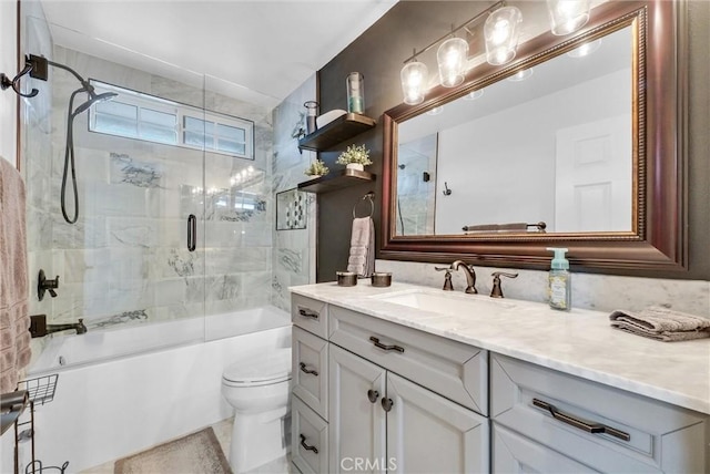 full bathroom featuring toilet, vanity, and bath / shower combo with glass door