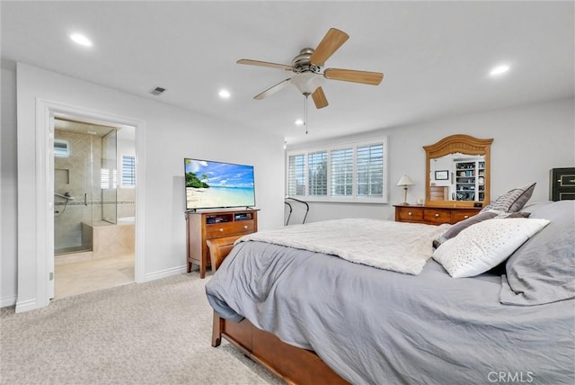 carpeted bedroom featuring multiple windows, ensuite bath, and ceiling fan