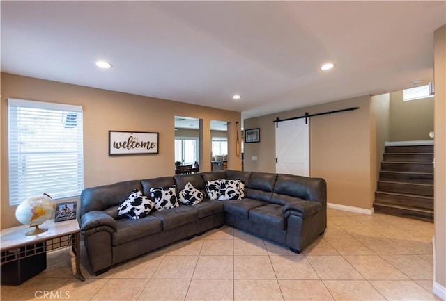 living room with a wealth of natural light, a barn door, and light tile patterned floors