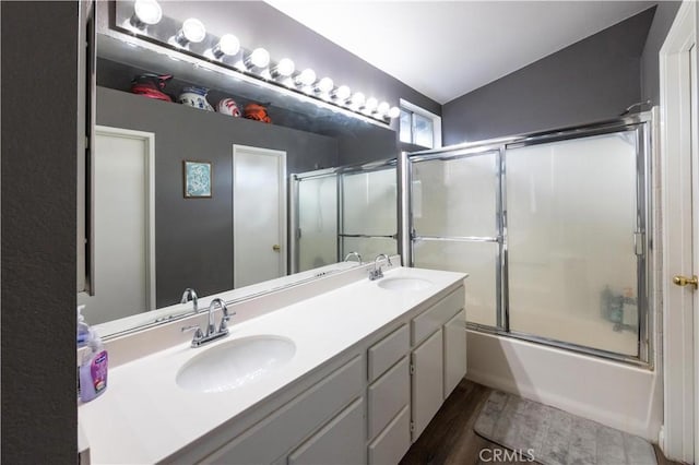 bathroom with lofted ceiling, shower / bath combination with glass door, hardwood / wood-style floors, and vanity