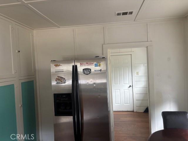 kitchen with wood-type flooring and stainless steel fridge