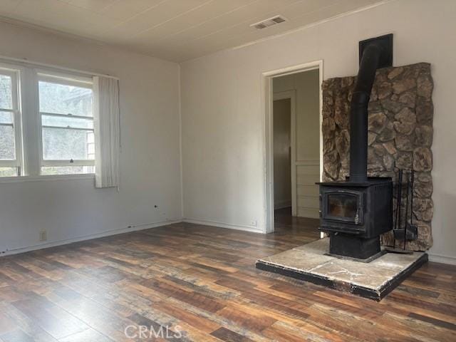 unfurnished living room with dark hardwood / wood-style floors and a wood stove