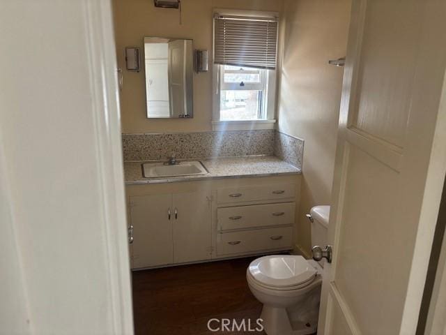 bathroom with vanity, wood-type flooring, and toilet