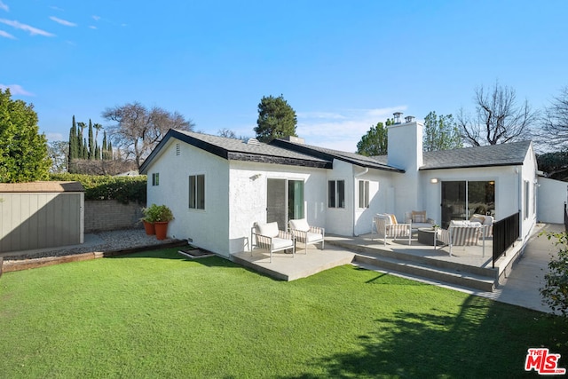 rear view of house featuring a yard and a patio area