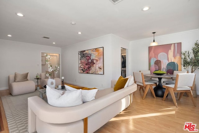 living room featuring crown molding and light hardwood / wood-style flooring