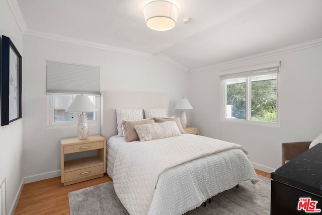 bedroom featuring crown molding, lofted ceiling, and wood-type flooring