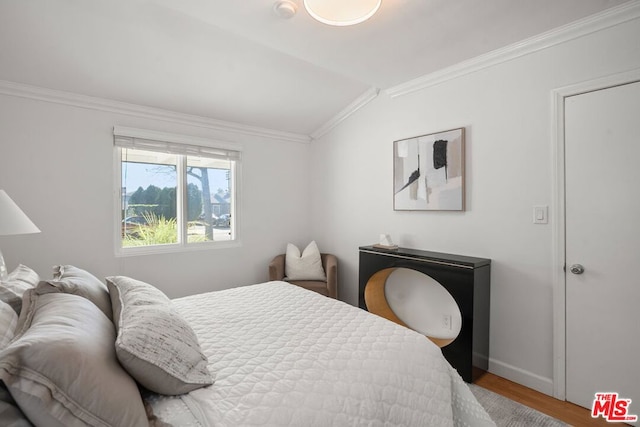 bedroom with crown molding, lofted ceiling, and wood-type flooring