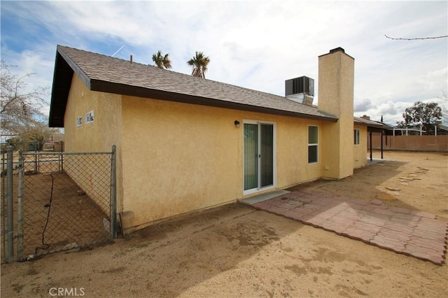 rear view of house with central AC and a patio area