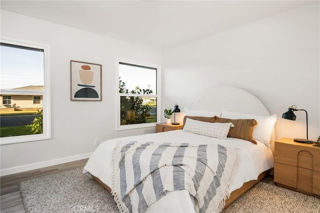 bedroom featuring baseboards and wood finished floors