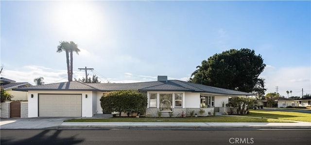 view of front of property with a garage, driveway, a front yard, and stucco siding