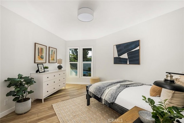 bedroom with light wood-type flooring and baseboards