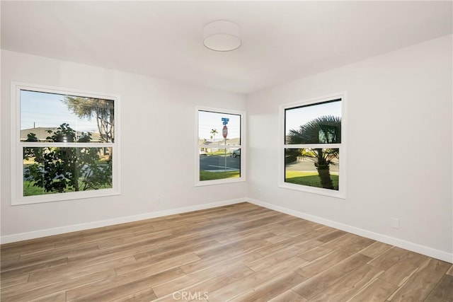 spare room with light wood-style floors and baseboards