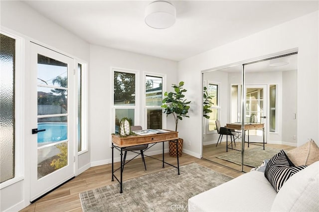 office area featuring baseboards and light wood finished floors