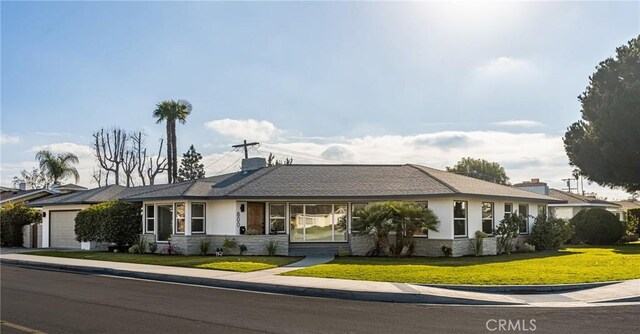 ranch-style house with a garage and a front lawn