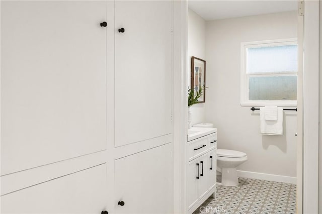 bathroom featuring toilet, tile patterned floors, baseboards, and vanity