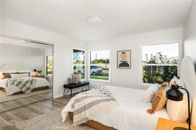 bedroom featuring baseboards, a closet, and wood finished floors