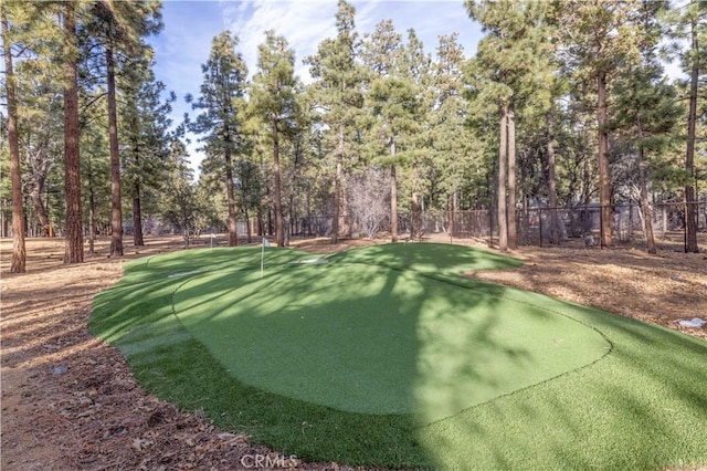 view of property's community featuring view of golf course and fence