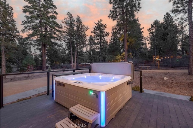 deck at dusk with a hot tub