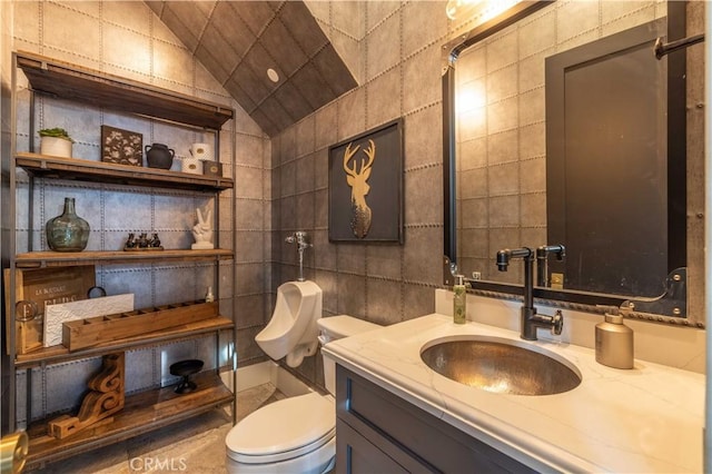 bathroom featuring lofted ceiling, tile walls, toilet, and vanity