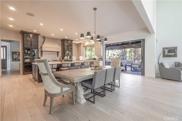 dining room featuring baseboards, an inviting chandelier, light wood-style flooring, and recessed lighting