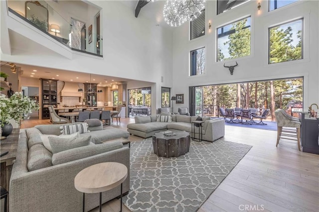 living area with hardwood / wood-style flooring, plenty of natural light, and a notable chandelier