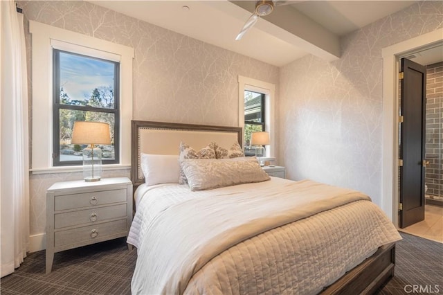 bedroom featuring beamed ceiling and wallpapered walls