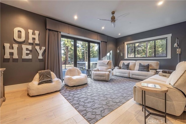 living area with recessed lighting, ceiling fan, and light wood-style flooring