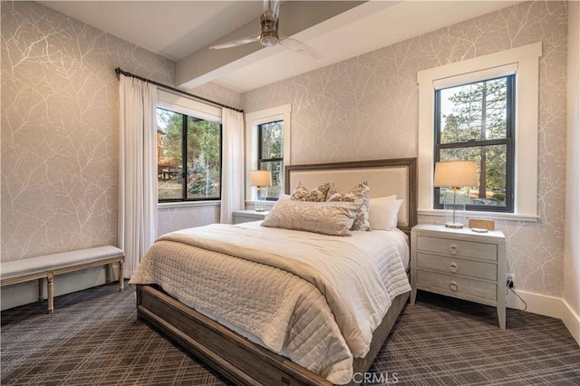 bedroom with dark colored carpet, multiple windows, and wallpapered walls