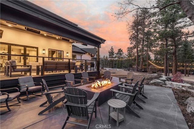 patio terrace at dusk featuring a fire pit