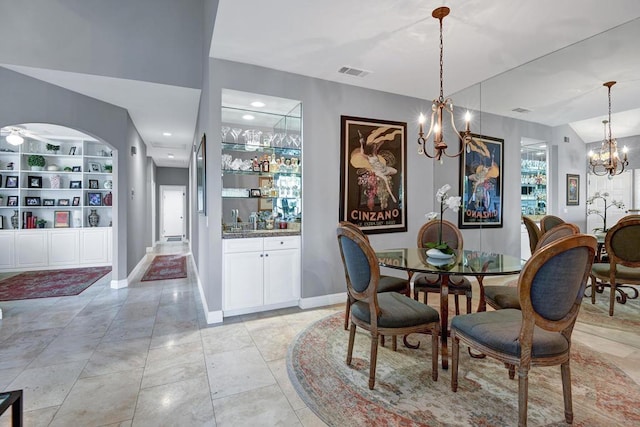 dining area with built in shelves, light tile patterned floors, vaulted ceiling, and a notable chandelier