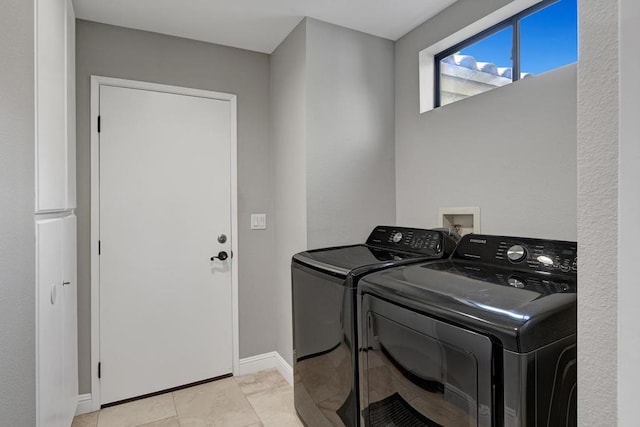 laundry area with washing machine and dryer and light tile patterned floors