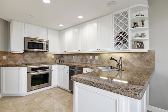 kitchen with stainless steel appliances, kitchen peninsula, sink, and white cabinets