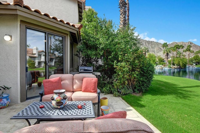 view of patio / terrace with a water and mountain view