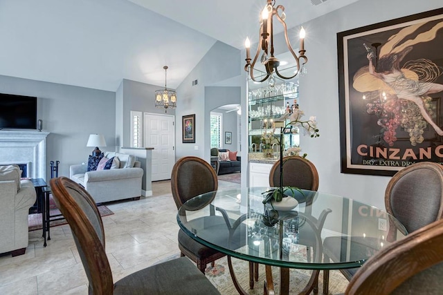 dining room featuring ceiling fan with notable chandelier and high vaulted ceiling