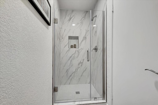 bathroom featuring a shower with door