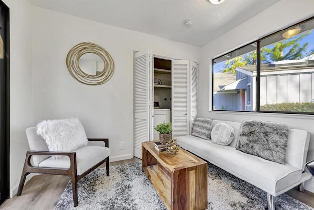 living area with washer / dryer and light hardwood / wood-style flooring