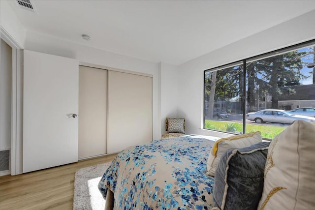 bedroom with light wood-type flooring and a closet