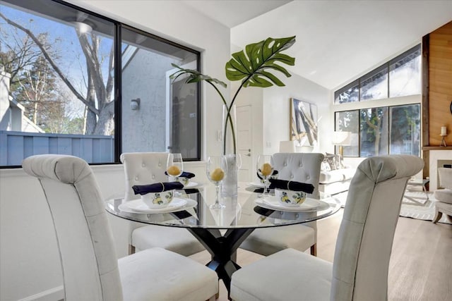 dining space with hardwood / wood-style flooring and vaulted ceiling