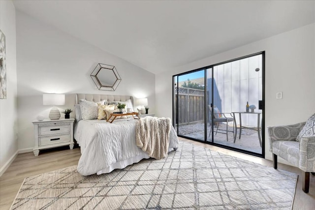 bedroom with light hardwood / wood-style flooring, access to outside, and vaulted ceiling