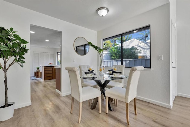 dining room with a wealth of natural light and light hardwood / wood-style floors