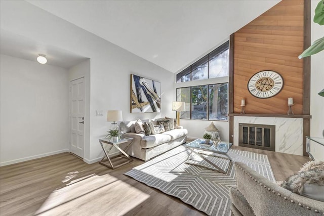 living room featuring hardwood / wood-style flooring, high vaulted ceiling, and a fireplace